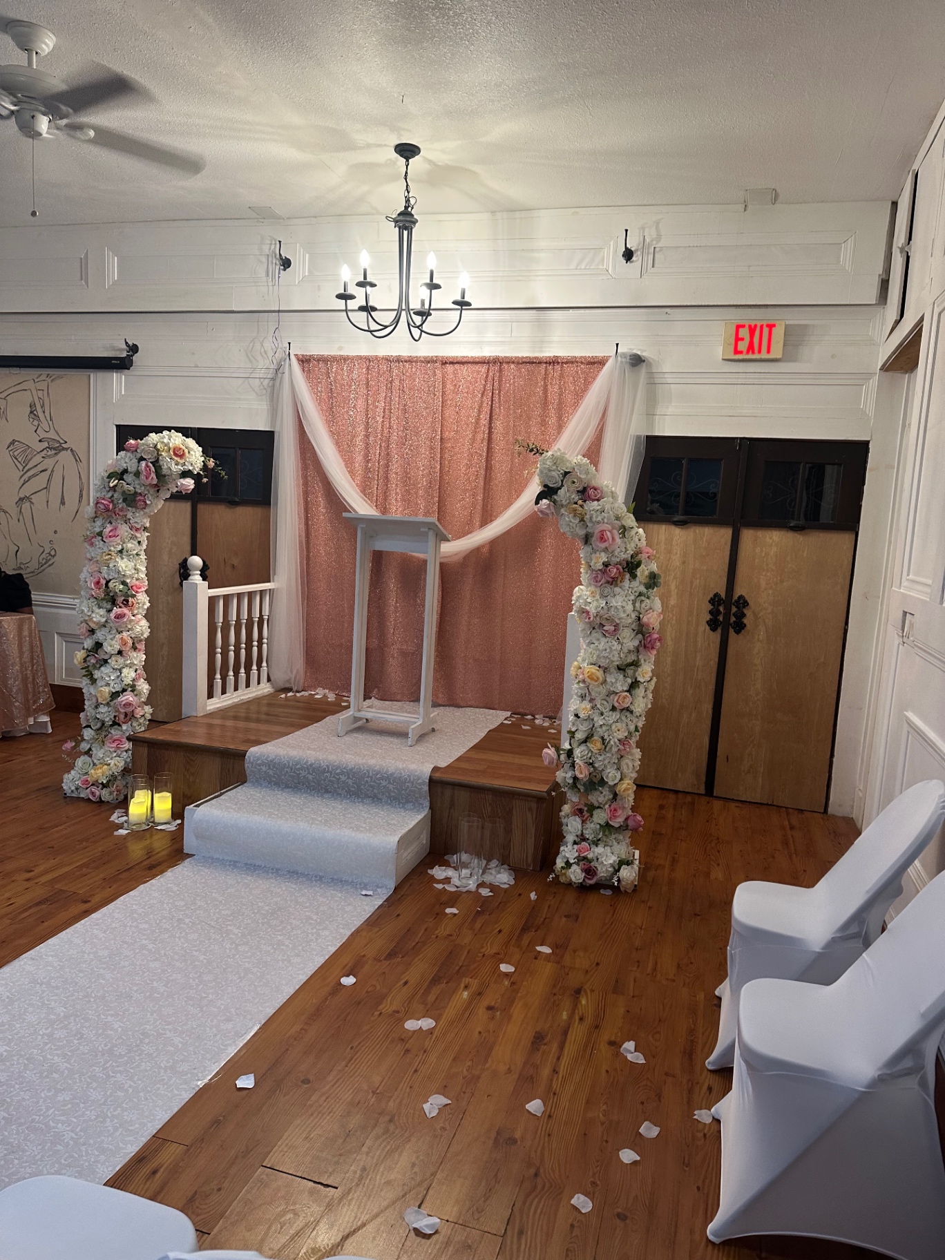 Wedding ceremony with floral arches and rose backdrop